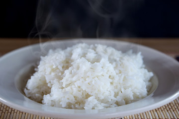cooked hot rice in white plate with smoke in background 