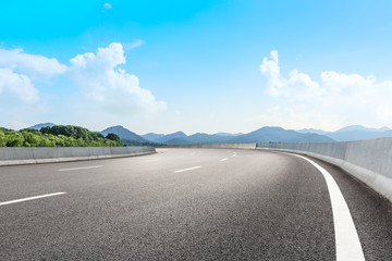 Asphalt road and beautiful mountain under the blue sky