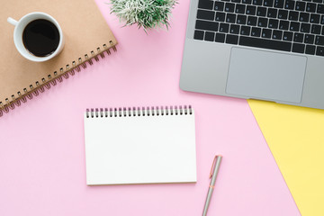 Creative flat lay photo of workspace desk. Top view office desk with laptop, blank empty notebooks and coffee cup on pastel color background. Top view with copy space, flat lay photography.