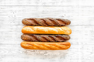 Baguettes. White and brown on white wooden background top view copy space