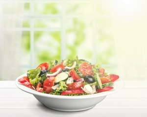 Close-up photo of fresh salad with vegetables in white plate