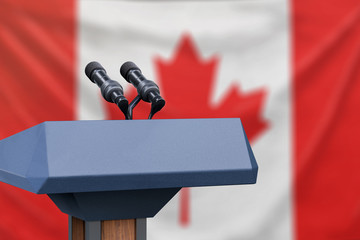 Podium lectern with two microphones and Canadian flag in background