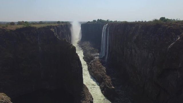 Drone shot of happy people celebrating at the viewpoint of Victoria Falls from Zambia, during dry season