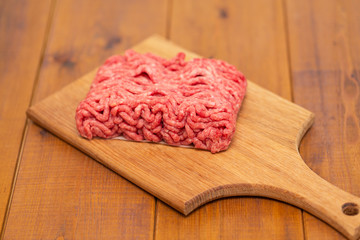 Portion of Minced Meat on an wooden table 