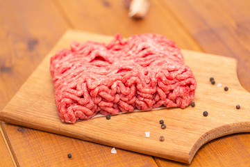Portion of Minced Meat on an wooden table 