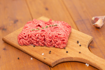 Portion of Minced Meat on an wooden table 