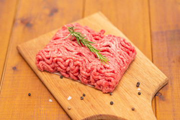 Portion of Minced Meat on an wooden table 