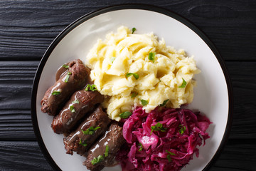 German beef rouladen recipe, along with mashed potato and red cabbage close-up. Horizontal top view