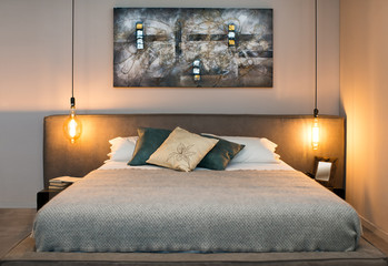 Concept of cozy bedroom with warm lamps