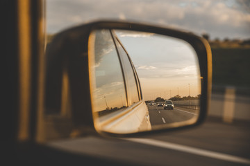 car on highway. sunset in car mirror reflection