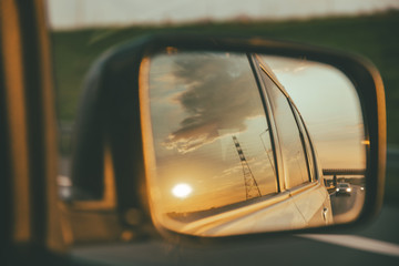 car on highway. sunset in car mirror reflection