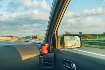 sunset reflection in car mirror on highway