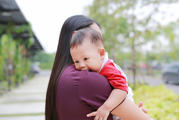 Close-up Asian baby boy lying in hug of mother