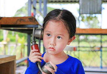 Cute asian kid girl using the retro telephone.