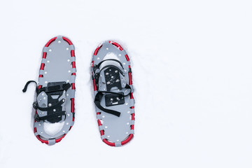 snowshoes lie on white snow, right on the snow is a place for the inscription