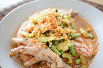 Rice noodles in fish curry sauce with chicken feet.