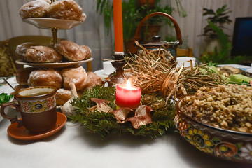 Traditional Christmas family dinner in Ukraine, twelve meatless dishes, burning candle. selective focus