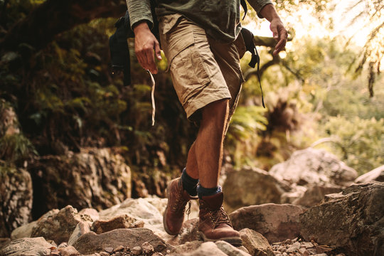Man in trekking gear hiking on rocky trail