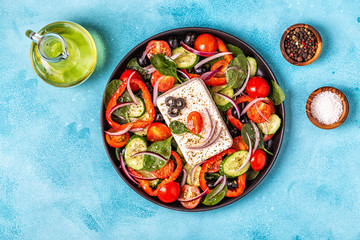 Greek salad of fresh cucumber, tomato, sweet pepper, spinach, red onion, feta cheese and olives