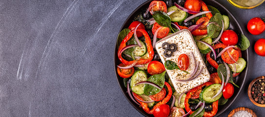 Greek salad of fresh cucumber, tomato, sweet pepper, spinach, red onion, feta cheese and olives