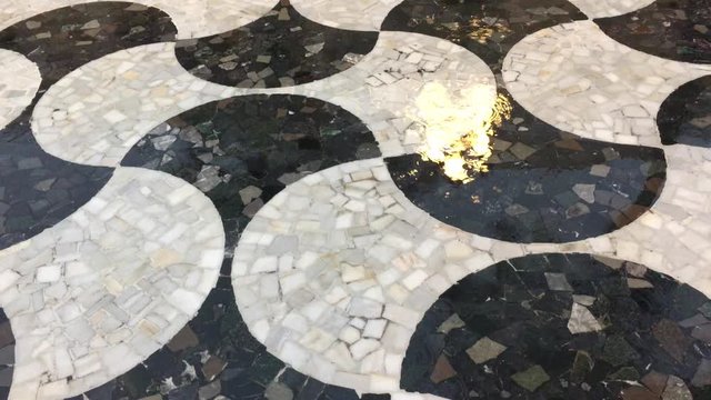 Lluvia sobre suelo de mosaico en la ciudad.