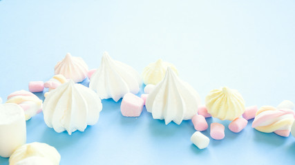 Fototapeta na wymiar various pastel marshmallows on a blue background