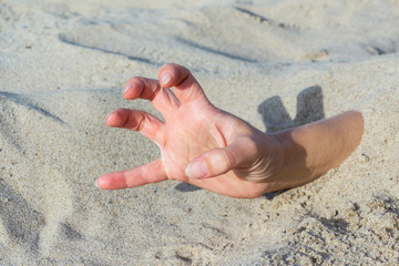 Hand closeup. Hands buried in sand on a beach.