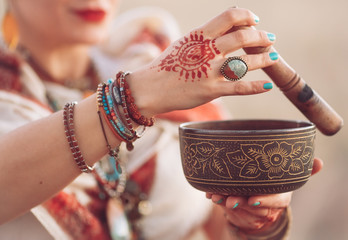 concept. Woman playing a Tibetan bowl. Pregnant woman doing yoga in the field at sunset.