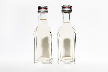 Two bottles of vintage alcohol with shadows in the shape of the heads of two young men.