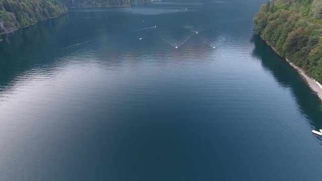 Aerial view of a sailboat on alpine lake Ritsa catamaran Parking, destination high in mountains. Parking of catamarans against, catamarans stand on water, parking of catamarans in water near shore.
