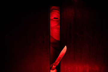 Serial killer / eye peeking behind the door with kinfe - 230761470