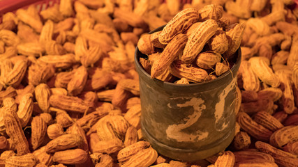 Ground nuts in a cup on a pile of ground nuts