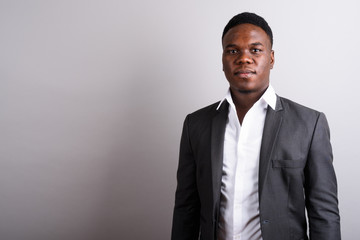 Young African businessman wearing suit against white background