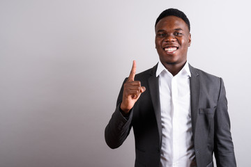 Young African businessman wearing suit against white background