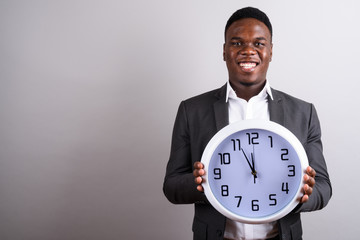 Young African businessman wearing suit against white background