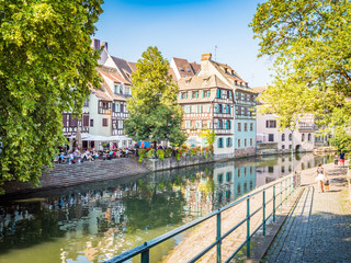 Fototapeta na wymiar Strasbourg, France - Aug 18, 2018: Picturesque canals in La Petite France in the medieval fairytale old town of Strasbourg, UNESCO World Heritage Site, Alsace, France.
