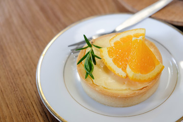 Lemon tart with closeup on dish with wooden texture.