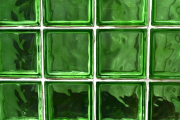 Green glass bricks background. Shiny green glass texture with sun light.