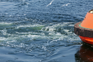 Track on the surface of the sea water behind the cargo sea ship. Trail on the surface of the water...