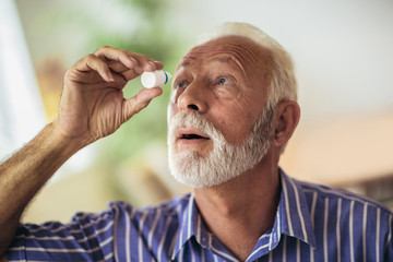 Elderly Person Using Eye Drops - obrazy, fototapety, plakaty
