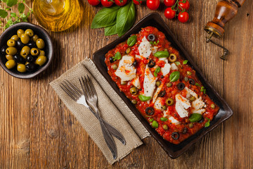 Cod in Italian in tomatoes with olives and capers.