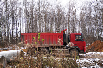                                 Red car - dump truck at work
