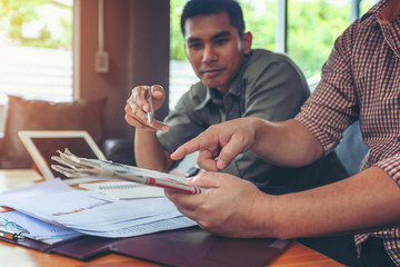 Financial planning Business man talking to planner financial business, report finance in paper on office accounting desk.