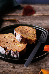 Slices of homemade Apple Cinnamon Coffee Cake on a plate with orange autumn leaves on old rustic wooden table. Selective focus