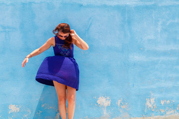 Attractive Slovak young woman posing by the blue wall