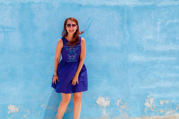 Naklejka premium Attractive Slovak young woman posing by the blue wall
