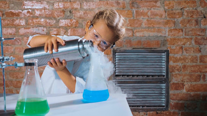 Cute child researcher is conducting an experiment with liquid nitrogen