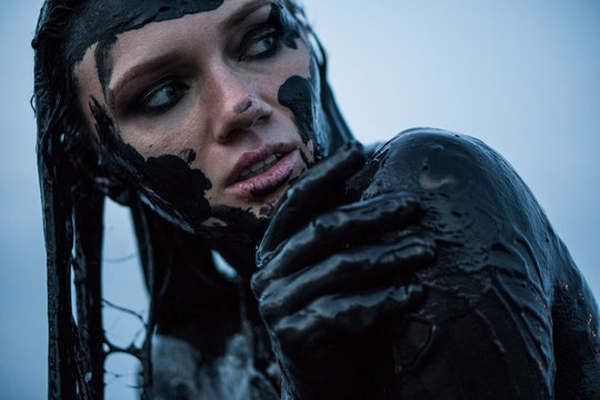 Portrait of a Caucasian Girl Smeared in a Healthy Black Mud