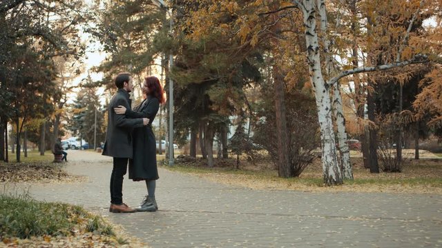 Lovely young couple meeting outdoors in the autumn city park.