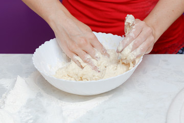 Making dough by female hands in bowl at home kitchen